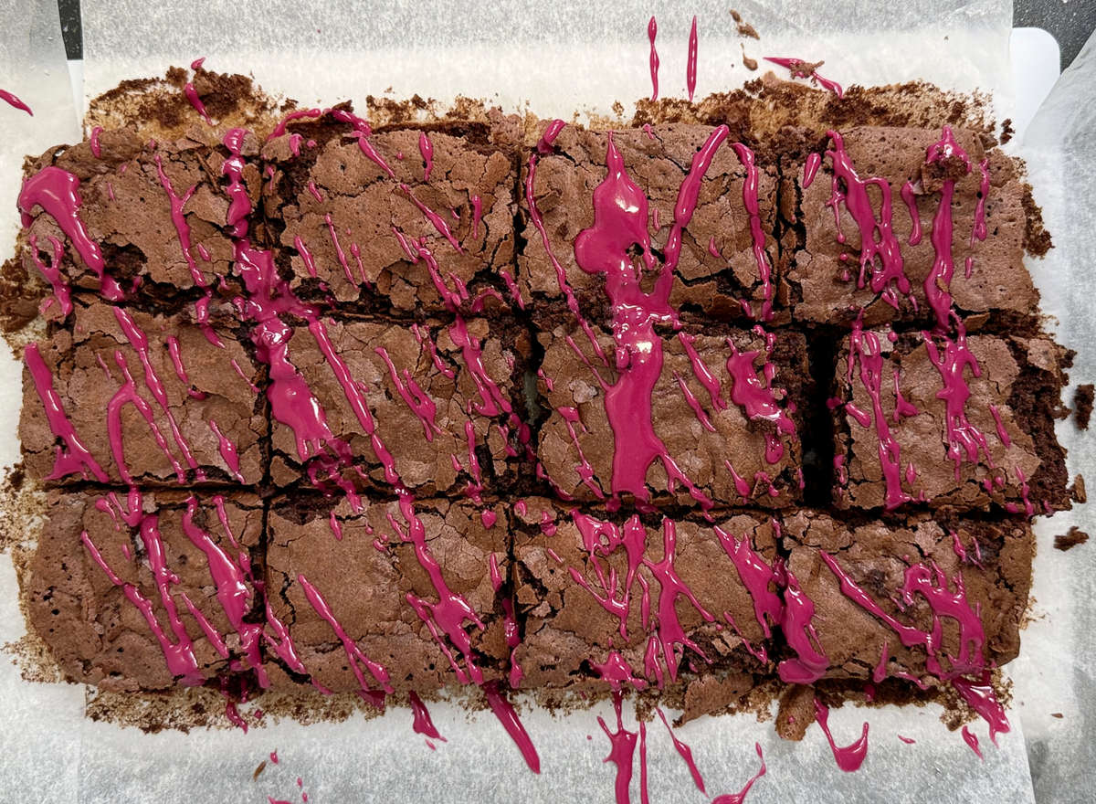 Top view of slices of brownies with pink icing.