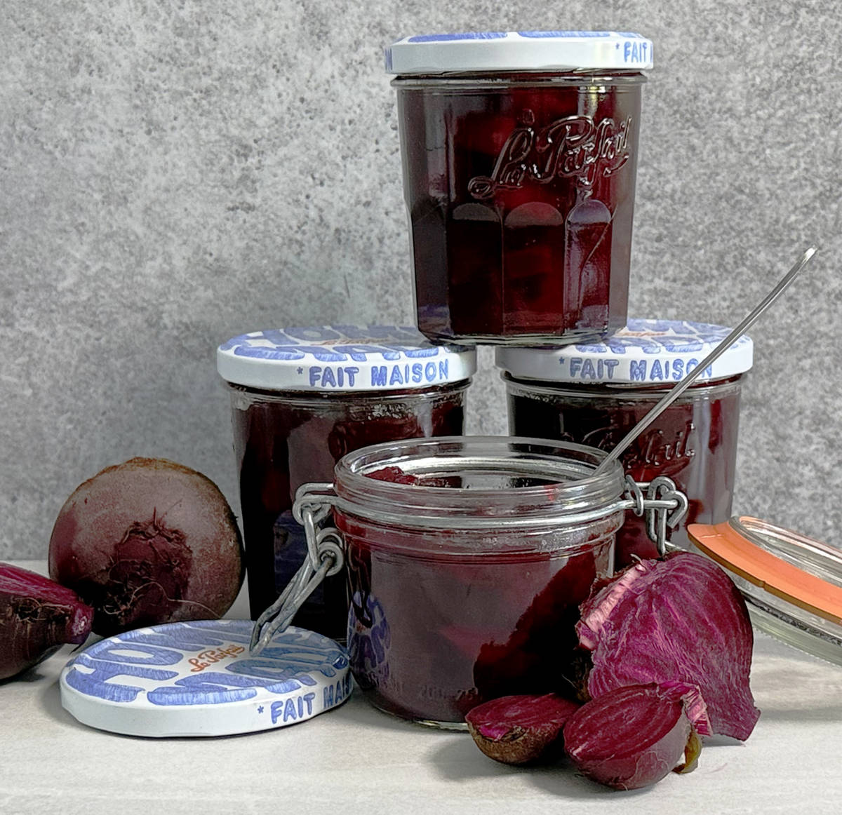 A jar of chutney with more jars in the background and freshly cut beetroot.