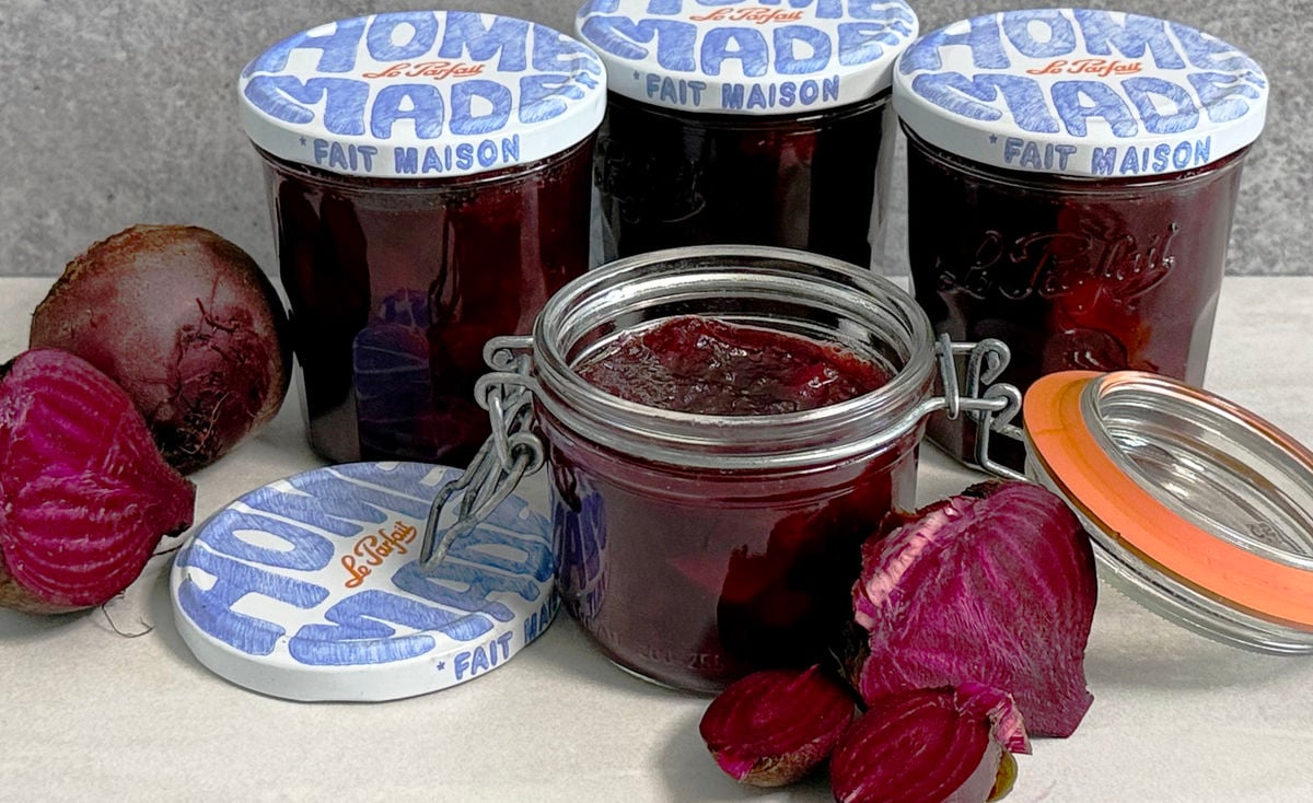 A jar of chutney with more jars in the background and freshly cut beetroot.